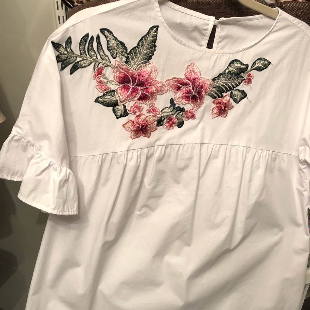 White top with flower appliqué